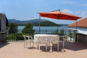 a table and chairs and an umbrella on a balcony at Apartments by the sea Luka Dubrava, Peljesac - 284 in Janjina