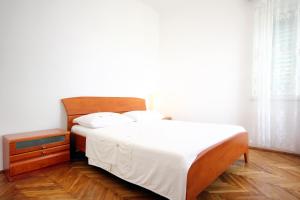 Schlafzimmer mit einem Bett mit weißer Bettwäsche und weißen Kissen in der Unterkunft Apartments by the sea Orebic, Peljesac - 251 in Orebić