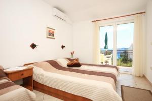 a bedroom with two beds with a dog laying on the bed at Apartments by the sea Orebic, Peljesac - 275 in Orebić