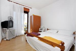 um quarto com uma cama e uma televisão em Apartments by the sea Sveti Petar, Biograd - 358 em Sveti Petar