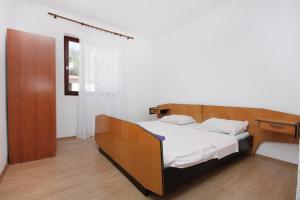 a bedroom with a bed with a wooden headboard at Apartments by the sea Sveti Petar, Biograd - 358 in Sveti Petar