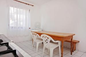 uma mesa de madeira e cadeiras num quarto com uma janela em Apartments by the sea Sveti Petar, Biograd - 358 em Sveti Petar