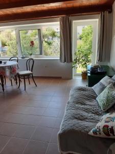 a bedroom with a bed and a table and windows at Apartments by the sea Nerezine, Losinj - 330 in Nerezine
