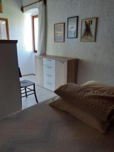 a bedroom with a bed and a dresser and a chair at Apartments by the sea Nerezine, Losinj - 330 in Nerezine