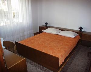 a bedroom with a large bed with two pillows at Apartments by the sea Podgora, Makarska - 316 in Podgora