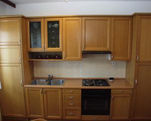 a kitchen with wooden cabinets and a sink at Apartments by the sea Podgora, Makarska - 316 in Podgora +21 photos