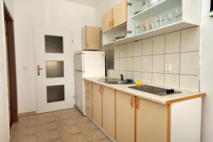 a kitchen with a sink and a refrigerator at Apartments by the sea Mrljane, Pasman - 319 in Neviđane