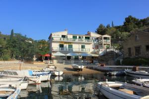 a group of boats docked in the water in front of a building at Apartments and rooms by the sea Zaglav, Dugi otok - 393 in Sali
