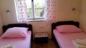 two twin beds in a room with a window at Apartment Valun 386a in Valun