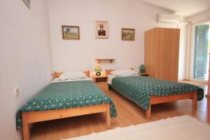 una camera con due letti con lenzuola verdi di Apartments and rooms by the sea Zaglav, Dugi otok - 393 a Sali (Sale)