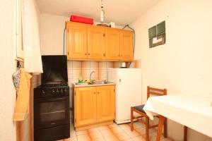 małą kuchnię z drewnianymi szafkami i lodówką w obiekcie Secluded fisherman's cottage Cove Ripisce, Dugi otok - 394 w mieście Brbinj +11 zdjęć