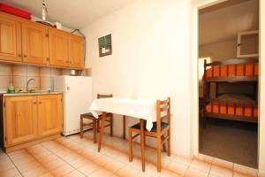 a kitchen with a table and a bunk bed at Secluded fisherman's cottage Cove Ripisce, Dugi otok - 394 in Brbinj
