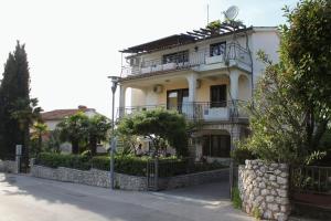 Une grande maison blanche avec balcon est située dans une rue. dans l'établissement Apartments and rooms with parking space Njivice, Krk - 408, à Njivice