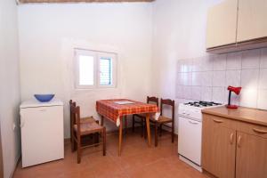 eine Küche mit einem Tisch, Stühlen und einem Herd in der Unterkunft Apartments with a parking space Biograd na Moru, Biograd - 368 in Biograd na Moru