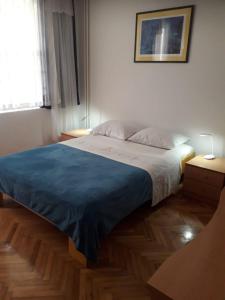 a bedroom with a large bed with a blue blanket at Apartments with a parking space Biograd na Moru, Biograd - 366 in Biograd na Moru