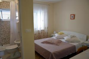 a small bedroom with a bed and a bathroom at Apartments by the sea Orebic, Peljesac - 269 in Orebić