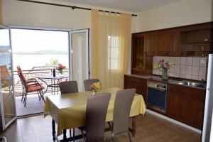 eine Küche und ein Esszimmer mit einem Tisch und einem Balkon in der Unterkunft Apartments by the sea Orebic, Peljesac - 269 in Orebić