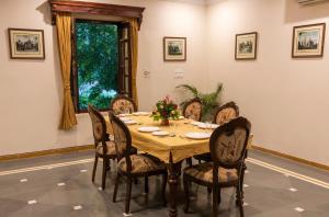 comedor con mesa de madera y sillas en Hanuwant Niwas Jodhpur en Jodhpur