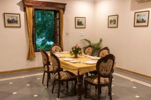 uma sala de jantar com uma mesa de madeira e cadeiras em Hanuwant Niwas Jodhpur em Jodhpur