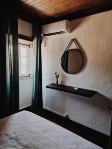 a bedroom with a bed and a mirror on the wall at Quinta Penedo das Antas - AL in Sertã