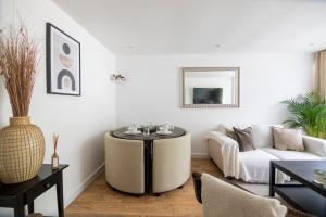 a living room with a table and a couch at Gorgeous Modern Apartment near Redhill Station inc Private Garden & Parking in Redhill