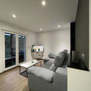 a living room with a couch and a tv at Apartamentos Toffe in Outes