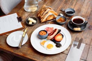 a wooden table with a plate of breakfast food at Room 3 - Glan Neigr in Rhosneigr