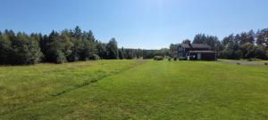 un grand champ vert avec une maison au loin dans l'établissement Cosy private cottage with stunning view, à Sunne