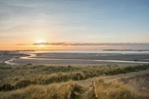 a sunset over a beach with the ocean at Room 3 - Glan Neigr in Rhosneigr
