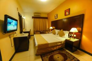 een hotelkamer met een bed en een flatscreen-tv bij Hyde Park Hotel in Dubai