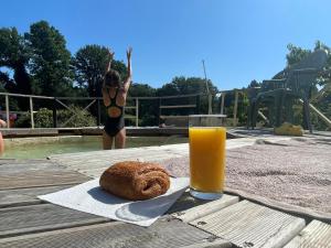 - une table avec un verre de jus d'orange et un bagel dans l'établissement L'ancienne ferme, à Bujaleuf