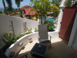 查汶的住宿－蘇梅島小花園度假酒店，一个带游泳池的阳台的椅子和桌子
