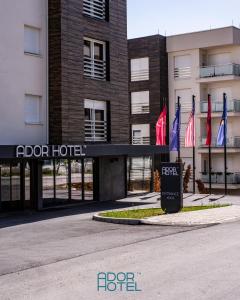 een hotel met vlaggen voor een gebouw bij Ador Hotel in Pristina