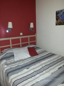 a bed in a bedroom with a red wall at Cap Estérel Agay St Raphaël vue mer in Agay - Saint Raphael