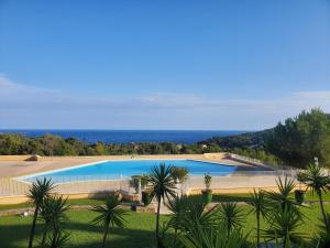 a large swimming pool with the ocean in the background at Village Cap Estérel Agay St Raphaël vue mer et piscine in Agay - Saint Raphael