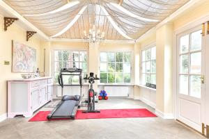 a room with a gym with a treadmill and a chandelier at Walcot Hall - Stunning Stately Home set in 27 acres of parkland and sleeping 16+ in Alkborough