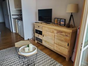 a living room with a tv on top of a dresser at Village Cap Estérel Agay St Raphaël vue mer et piscine in Agay - Saint Raphael