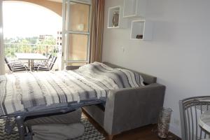 a bed with a blanket on top of it in a room at Village Cap Estérel Agay St Raphaël vue mer et piscine in Agay - Saint Raphael