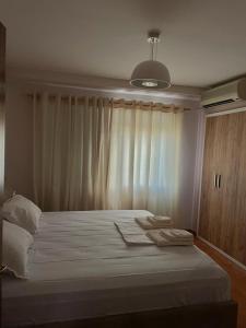 een slaapkamer met een groot wit bed en een raam bij Apartment in Skanderbeg Square - Tirana Center 1 in Tirana