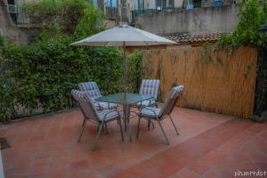 Una mesa y sillas con una sombrilla en un patio. en Palazzo Mannino Apartments, en Catania 11 fotos más