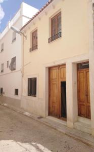 a house with wooden doors on a street at LA CASA DEL SOL in Pego