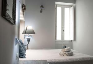 una camera con letto, lampada e finestra di Casa Vacanze L'essenziale a Martina Franca