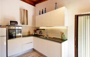 a kitchen with white cabinets and a sink at Nice Apartment Santo Stefano in Santo Stefano dʼAveto