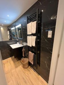 a black bathroom with a sink and a mirror at Het Waterhof in Leiden