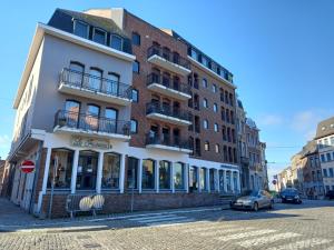 um edifício numa rua com um carro estacionado na frente em Au gîte de Binche em Binche