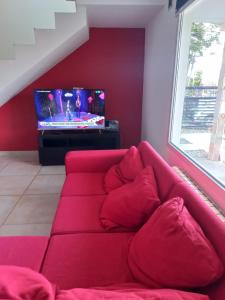 un sofá rojo en la sala de estar con TV en MODERNA CASA EN USHUAIA en Ushuaia
