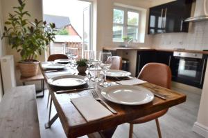 una mesa de madera con platos y gafas en la cocina en Park View en Hathern