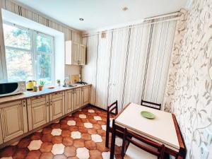 a kitchen with a table and chairs and a microwave at Квартира в центре Крещатика in Kyiv