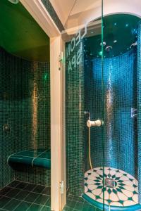 a bath tub sitting next to a shower in a bathroom at Seehotel Leoni in Berg am Starnberger See