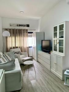salon z kanapą i telewizorem w obiekcie Apartamento en el Centro con Parking w mieście Tarifa